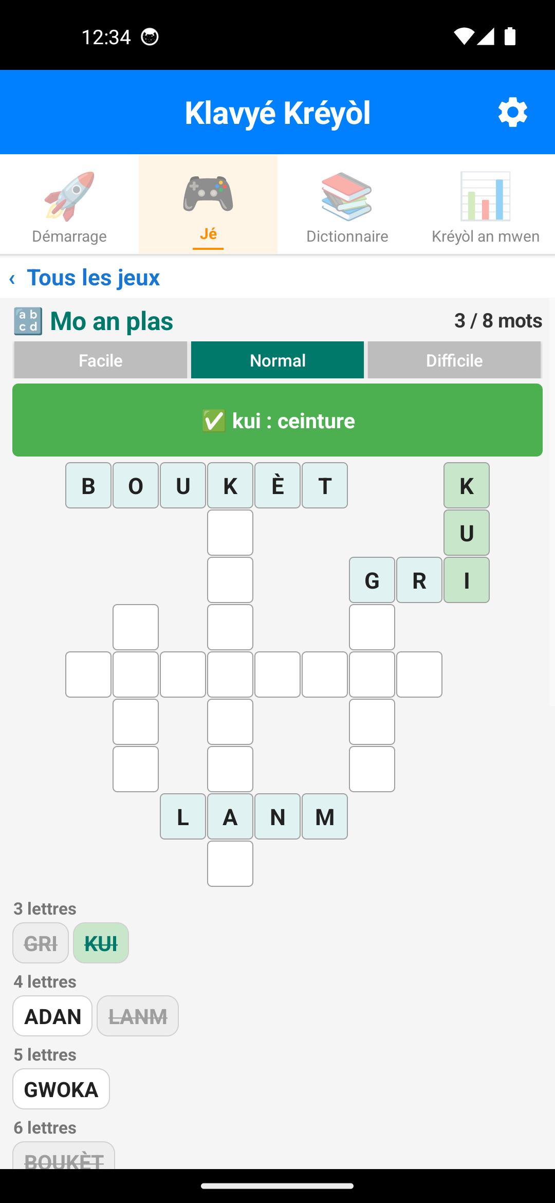 Jeu Mo an plas : les mots boukèt, gri, kui et lanm placés dans la grille, le bandeau affiche « kui : ceinture »